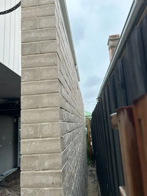 Grey blockwork boundary wall viewed from the opposite end of the side access