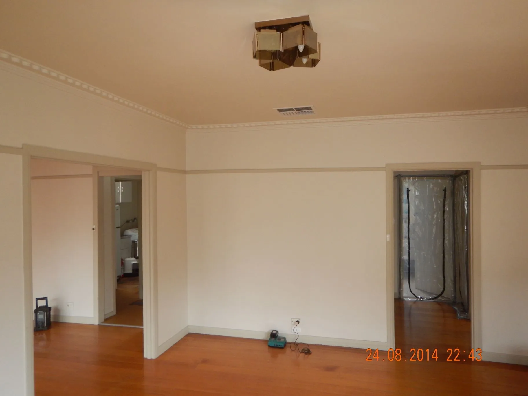 Existing Bentleigh East living room with timber floor, cornice, and feature wall