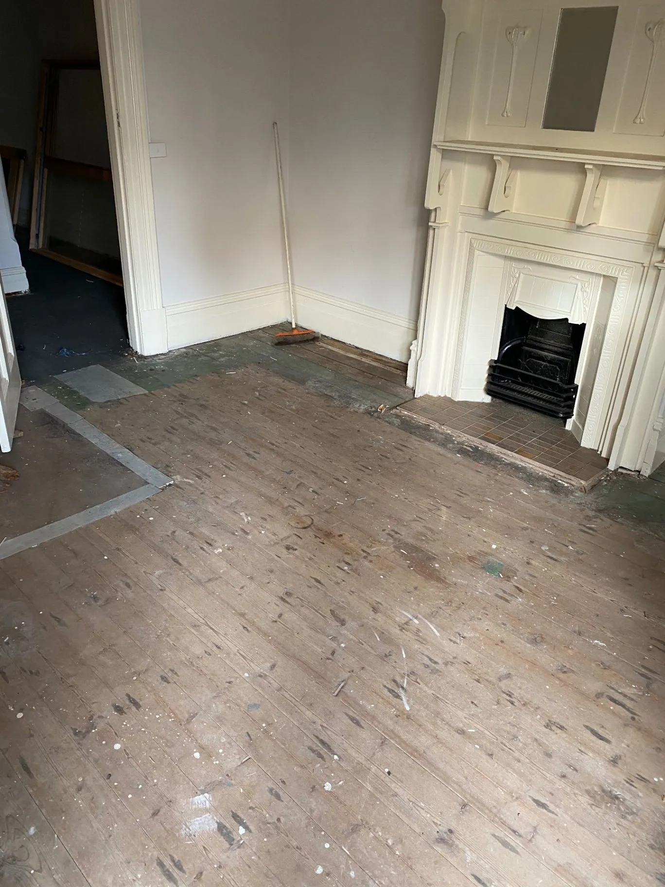 Elsternwick interior showing fireplace, skirting, and worn timber floorboards