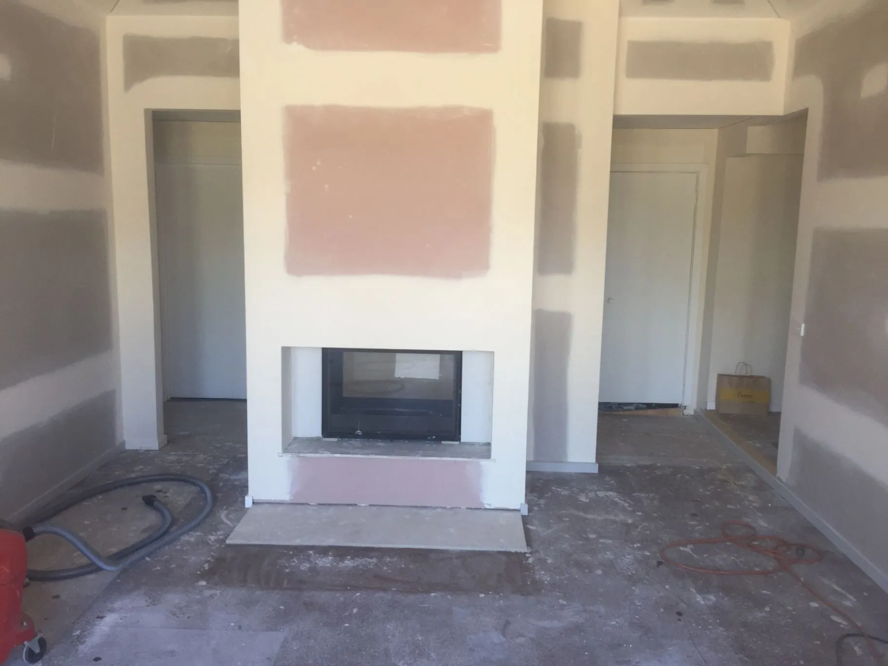 Interior fireplace surround and adjoining rooms during construction